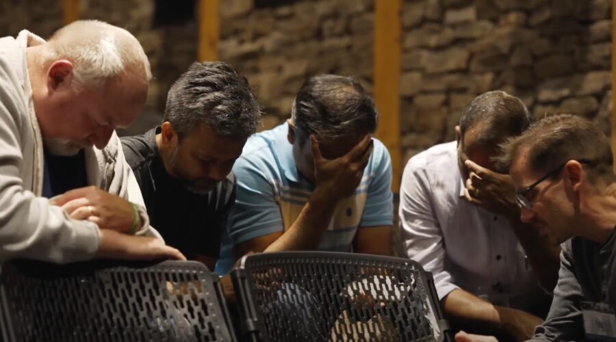 Men praying with their head in their hands