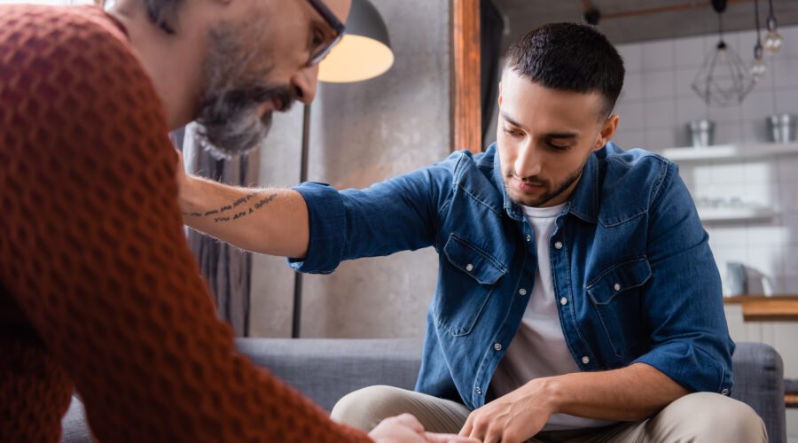 A man placing his hand on another man