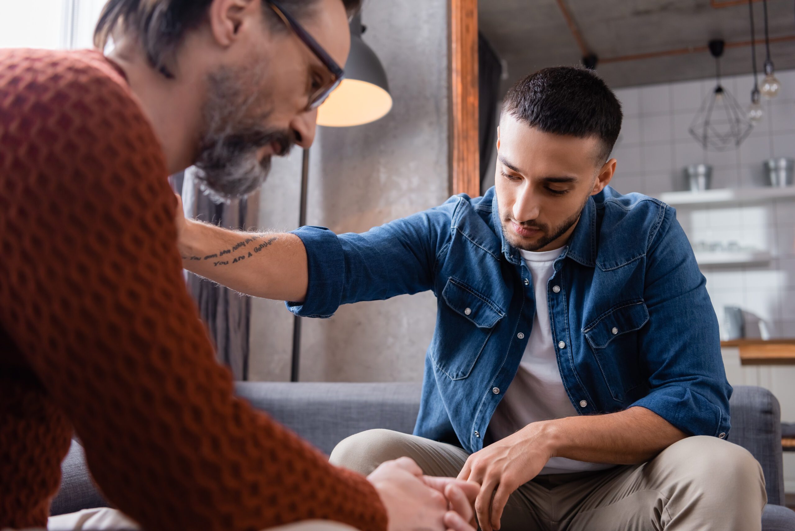 A man placing his hand on another man