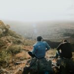 Men sitting on a rock and looking out over the countryside