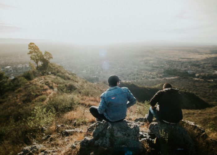 Men sitting on a rock and looking out over the countryside