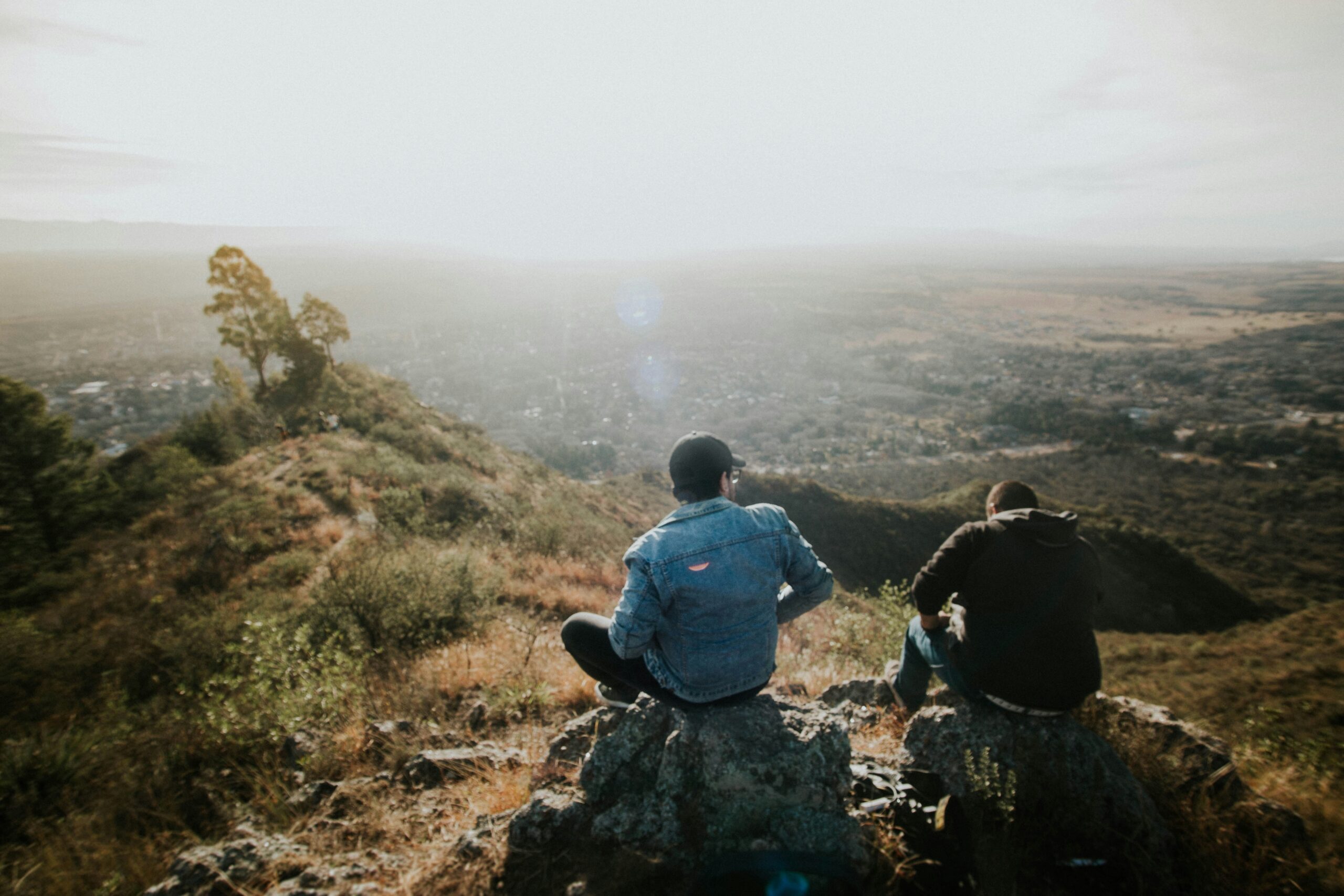 Men sitting on a rock and looking out over the countryside